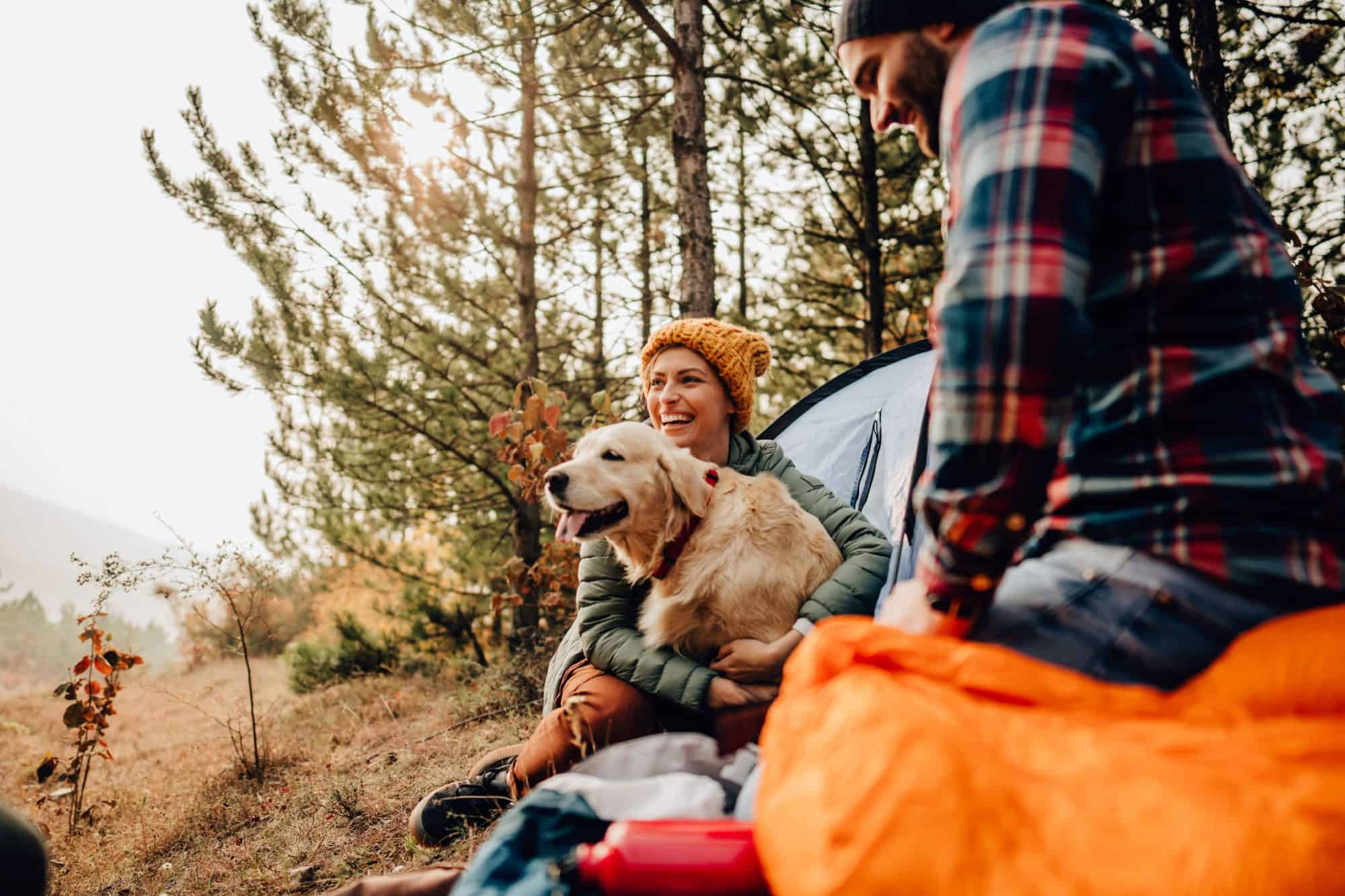 Happy couple hiking with dog.